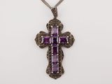 a purple cross pendant with a chain on a white background