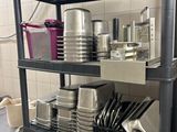 une étagère noire sur laquelle sont posés des casseroles et des poêles