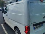 a white van parked in a parking lot with a surfboard on the roof