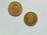 two gold coins sitting on top of a white surface next to each other