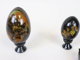 two black and gold eggs sitting next to each other