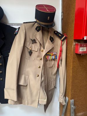 a coat and hat hanging on a wall next to a fire hydrant