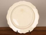 a white plate on a wooden table with a white wall in the background