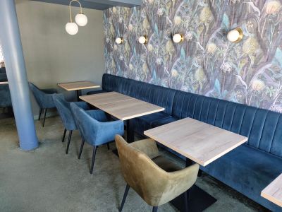 des tables et des chaises dans un restaurant, avec un mur tapissé en arrière-plan