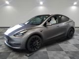 the silver tesla suv is parked in a large room