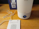 un humidificateur blanc posé sur une table en bois à côté d'une boîte