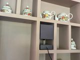 a shelf that has a bunch of tea pots on it