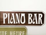 two street signs on a pole that say piano and suite heure