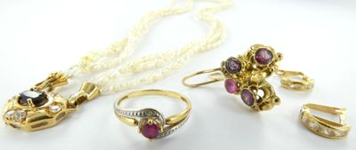 une photo représentant un ensemble composé d'un collier, d'une bague et d'une boucle d'oreille, posé sur un fond blanc