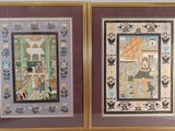 two framed pictures of a couple of paintings on a wall