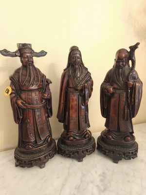 three asian figurines sitting on top of a table next to each other
