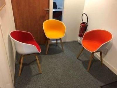 three chairs in the corner of a room with a fire extinguisher in the background