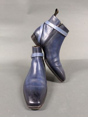 pair of men ' s blue leather ankle boots on a grey background