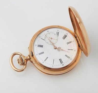 a gold pocket watch with roman numerals on it