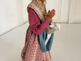 figurine of a woman in a pink dress holding a blue bag