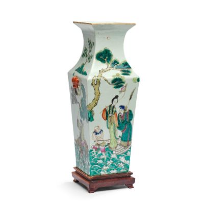 un vase orné d'une peinture, posé sur un socle en bois
