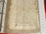 an old book with writing on it sitting on a table