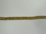 a close up of a gold bracelet on a white surface
