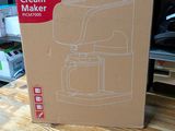 a box that is sitting on a table with a coffee maker in it