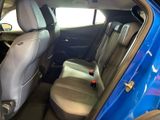 the back seats of a blue car with a bottle in the passenger seat