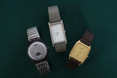 deux montres sont posées l'une à côté de l'autre sur une surface verte