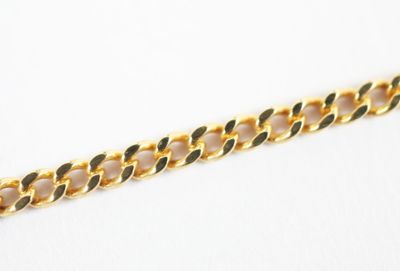 a close up of a gold chain on a white surface