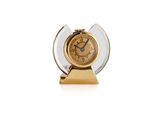 a clock that is sitting on a stand on a white surface