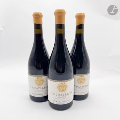 trois bouteilles de vin posées sur une table blanche