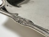 a silver plate with a spoon and spoon rest on it
