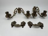 three antique brass candlesticks and a candle holder on a table