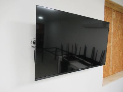un téléviseur à écran plat fixé au mur d'une pièce