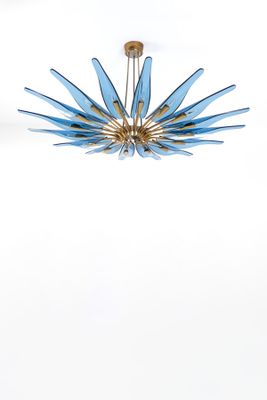 Le lustre bleu et or est suspendu au plafond.