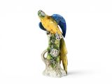 une figurine représentant un perroquet perché sur une souche d'arbre