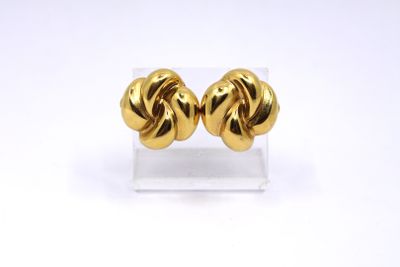 a pair of gold plated earrings on a clear stand