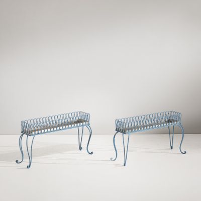 une paire de bancs en métal bleu aux pieds courbés, posés sur un sol blanc