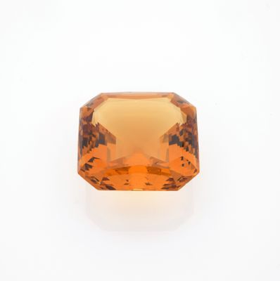 un gros plan d'un saphir orange sur une surface blanche