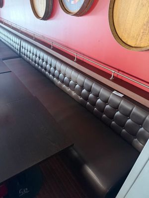 a long bench in the middle of a room with several wine barrels on the wall