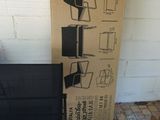 a black chair sitting in front of a box with a computer on it