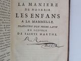 un livre ouvert, sur lequel figure un titre écrit à la main, posé sur une table