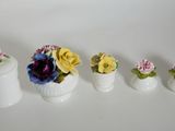 five small vases with flowers in them on a white surface