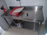 une table en métal sur laquelle se trouve un panier rouge