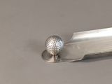 a golf ball sitting on top of a metal serving tray