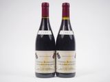 deux bouteilles de vin rouge posées l'une à côté de l'autre sur une surface blanche