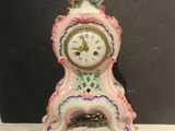 une horloge rose et blanche posée sur une table blanche