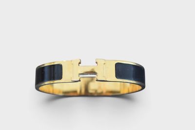 a close up of a gold ring with a black enamel band