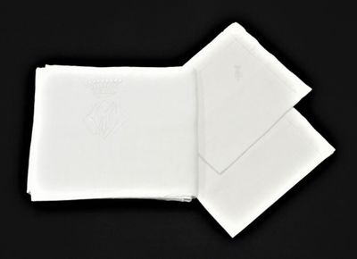 deux serviettes blanches sont pliées l'une sur l'autre sur une surface noire