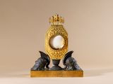 a gold clock with a pearl in the middle of it