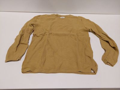 an image of a tan sweater on a white table