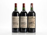 three bottles of wine are lined up on a white surface