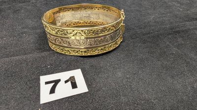 une image représentant une plaque en or sur laquelle figure le chiffre 71